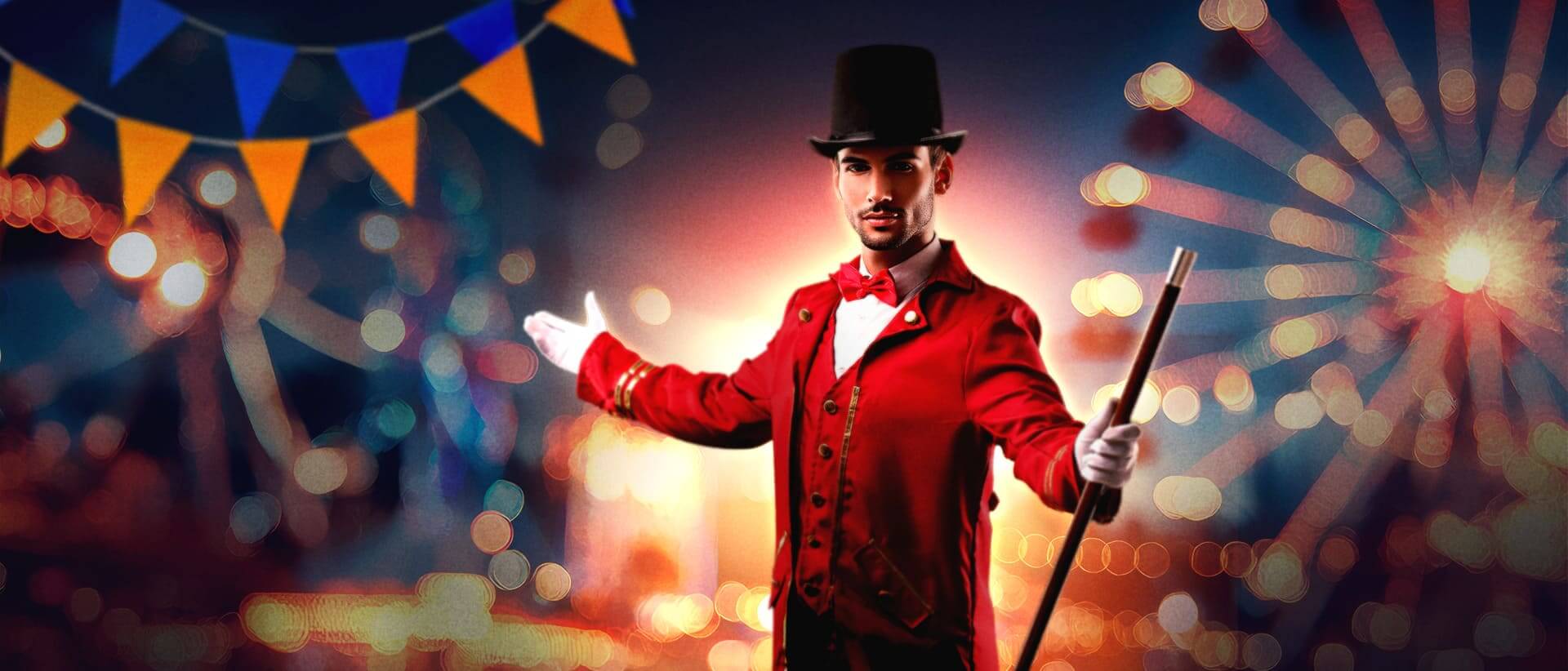 A man in a red ringmaster outfit with white gloves and a top hat gestures with one arm, standing in front of a vibrant carnival backdrop with lights, ferris wheels, and orange and blue pennant flags.