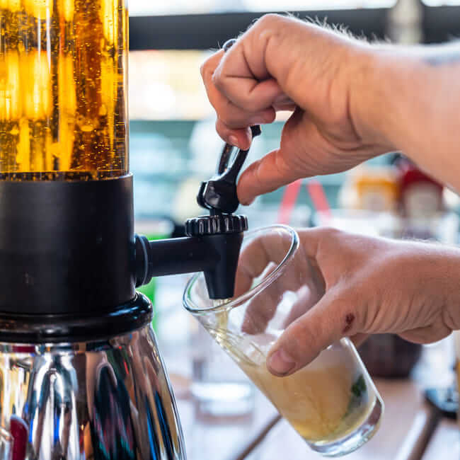 Close-up of a bartender pouring a draft beer from a tap into a glass